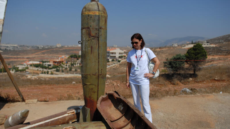 A campaigner stands by U.S. cluster munition remnants displayed at a field visit to Nabatiye during the convention's Second Meeting of States Parties (c) HRW, September 12, 2011