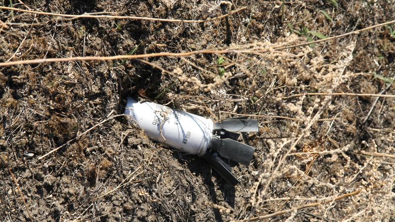 An unexploded submunition lies in a field in eastern Ukraine (c) Human Rights Watch, October 2014