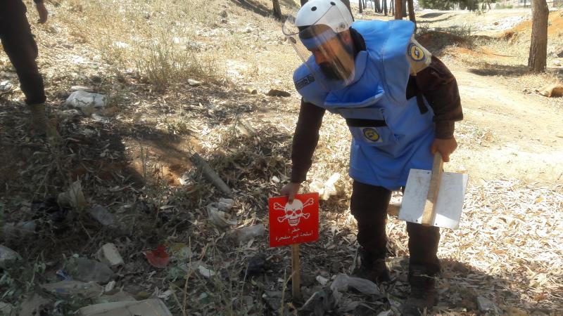 Trained technicians from Syria Civil Defense (“White Helmets”) identify and mark unexploded submunitions and other explosive remnants of war for clearance and destruction in Idlib governorate on June 8, 2017. © 2017 Syria Civil Defense